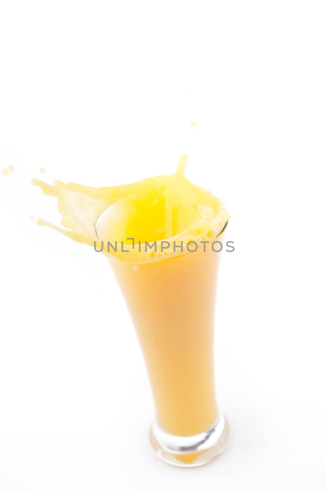 Overlowing glass of orange juice against white background