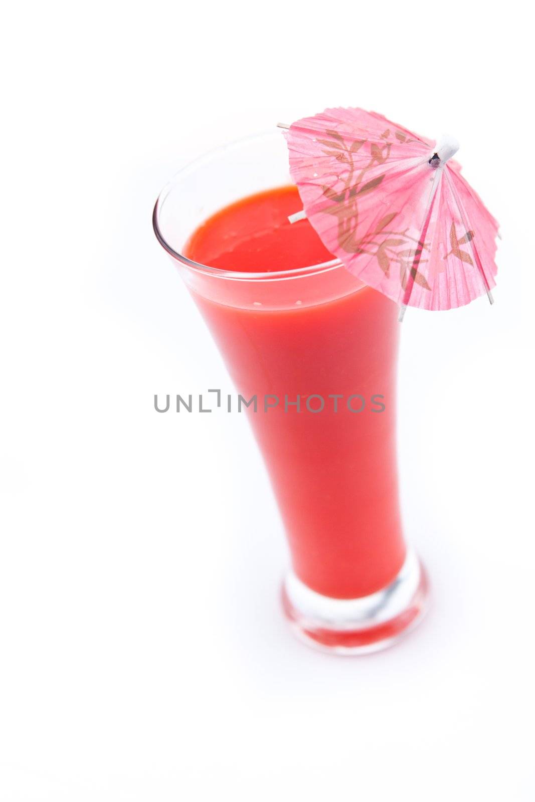 Cocktail umbrella in a berries juice against white background