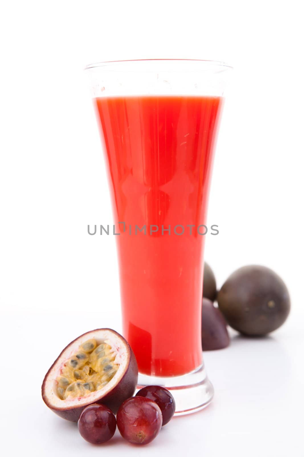 Full glass behind berries against white background