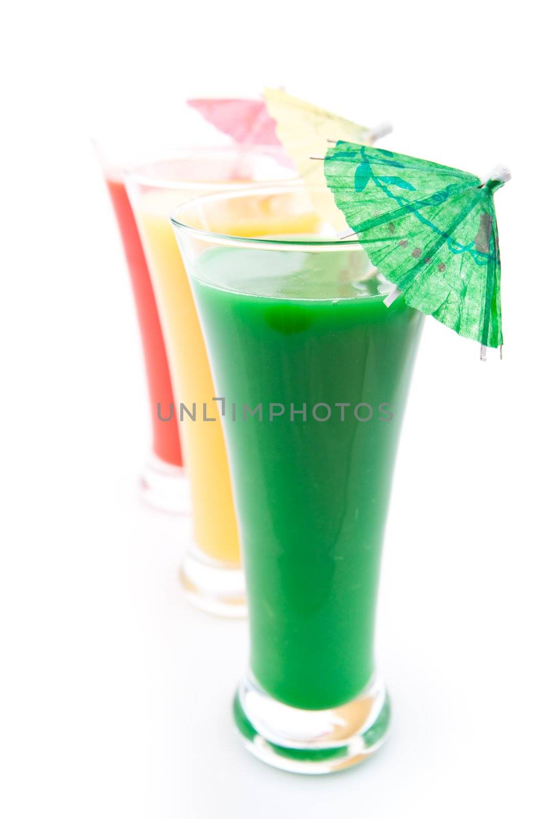 Row of glasses with cocktail umbrellas against white background