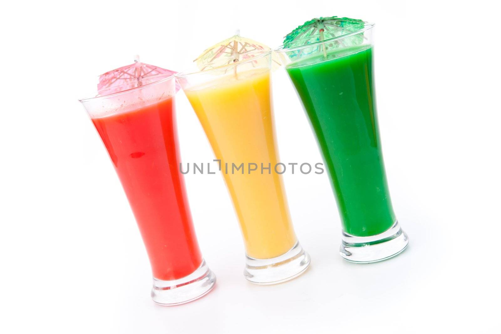 Cocktail umbrellas in a row of glasses against white background