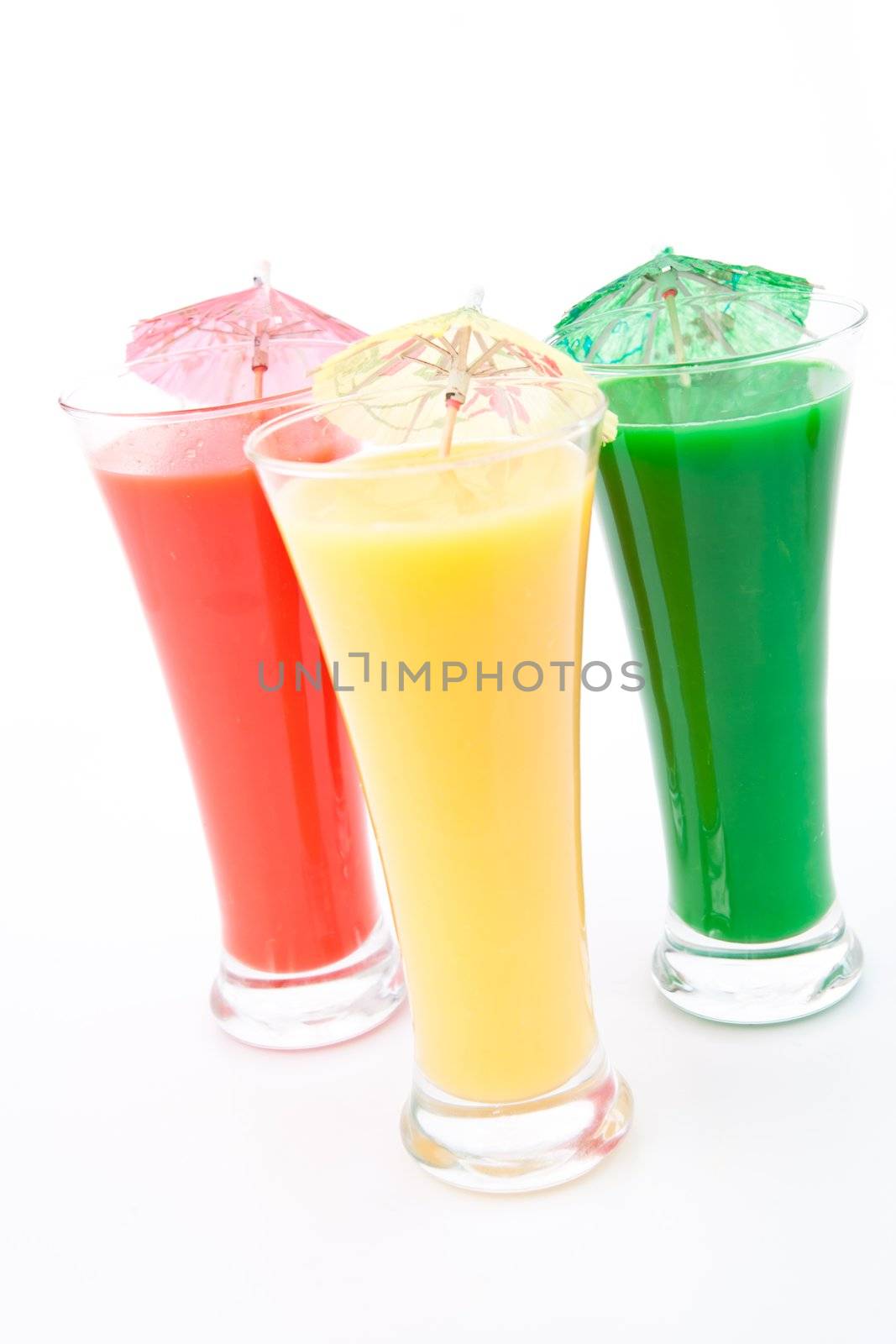 Three glasses with cocktail umbrella against white background