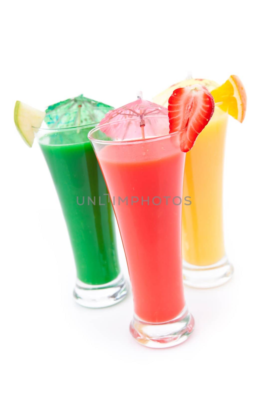 Fruit pieces and cocktail umbrella on glasses against white background