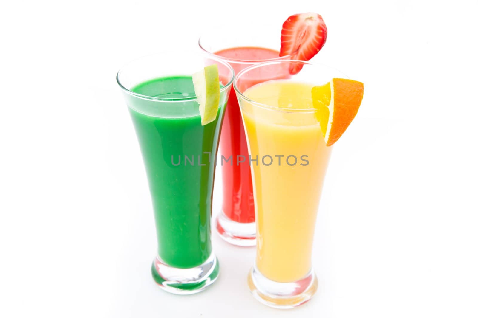 Fruit pieces in three full glasses against white background