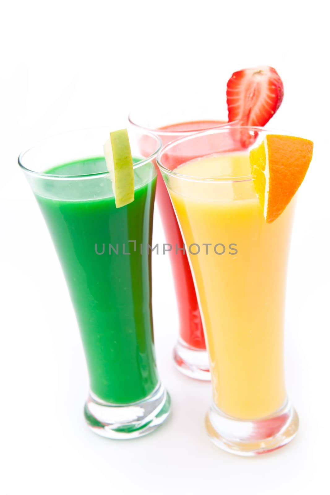 Full glasses with fruits pieces against white background