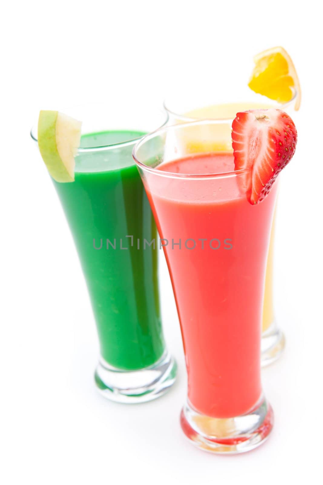Three full glasses with fruit pieces against white background