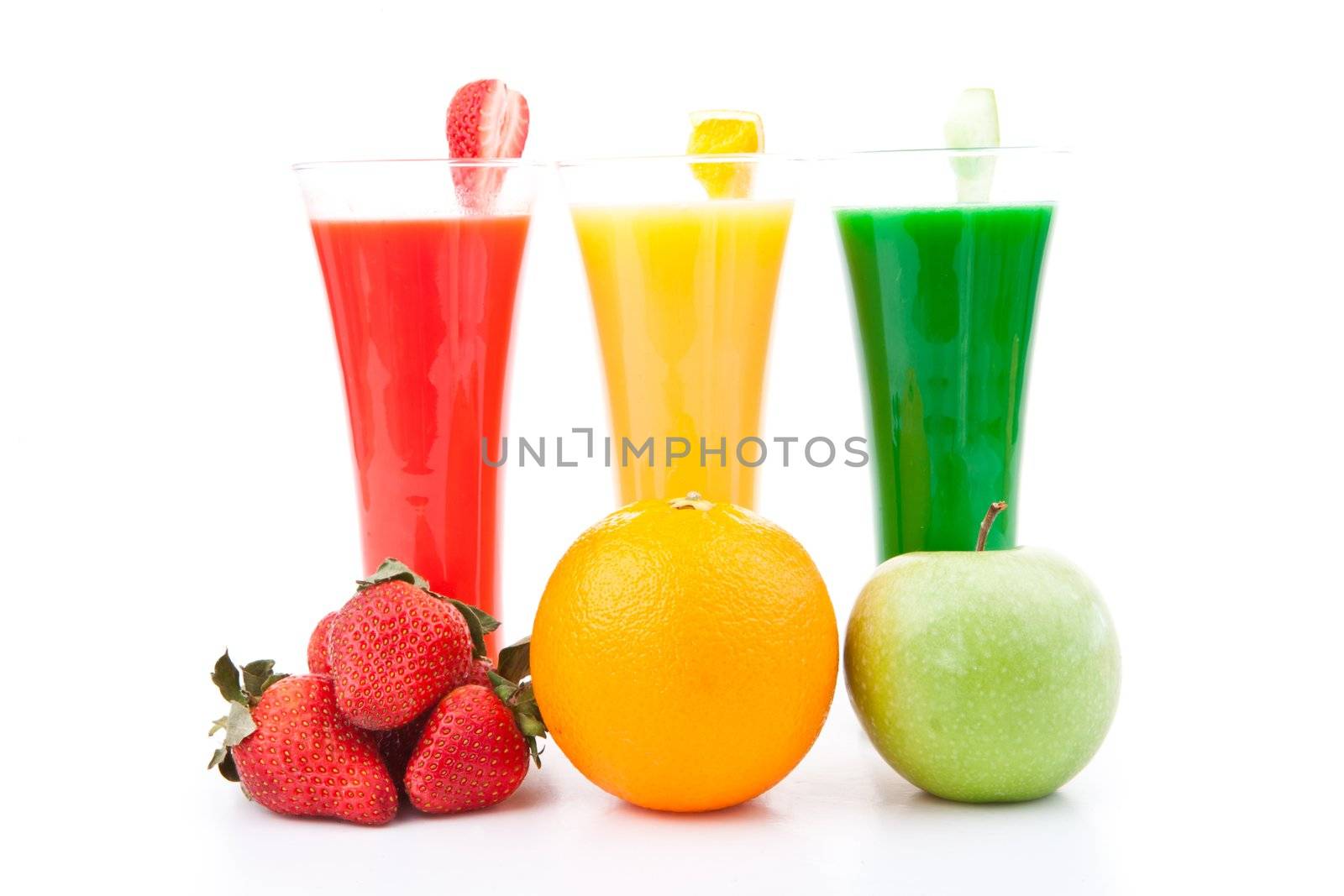 fruits placed in front of full glasses against white background