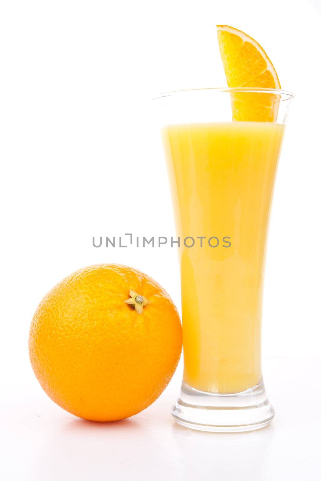 Orange placed next to a glass of orange juice against white background