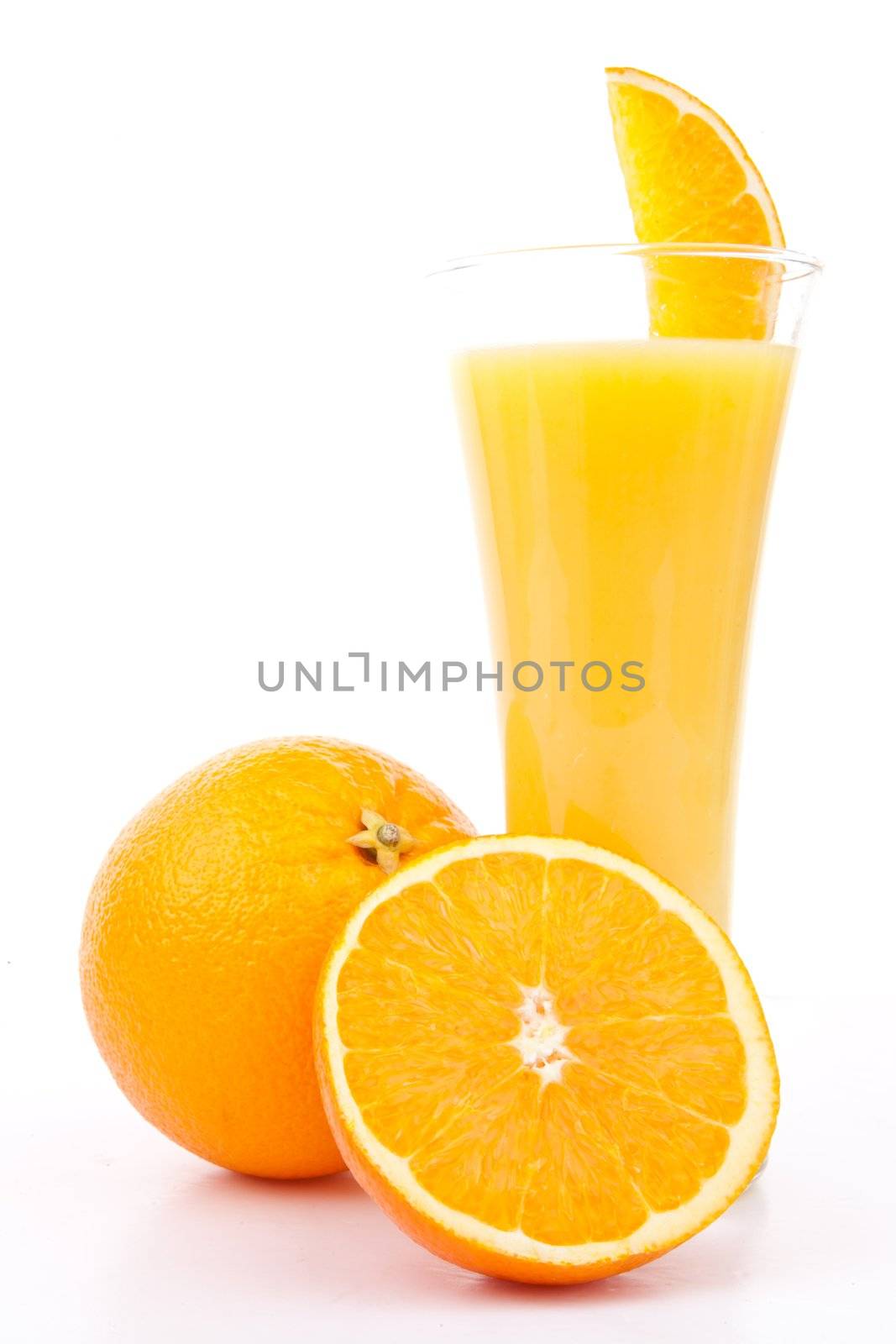 One orange and a half next to a glass of orange juice against white background