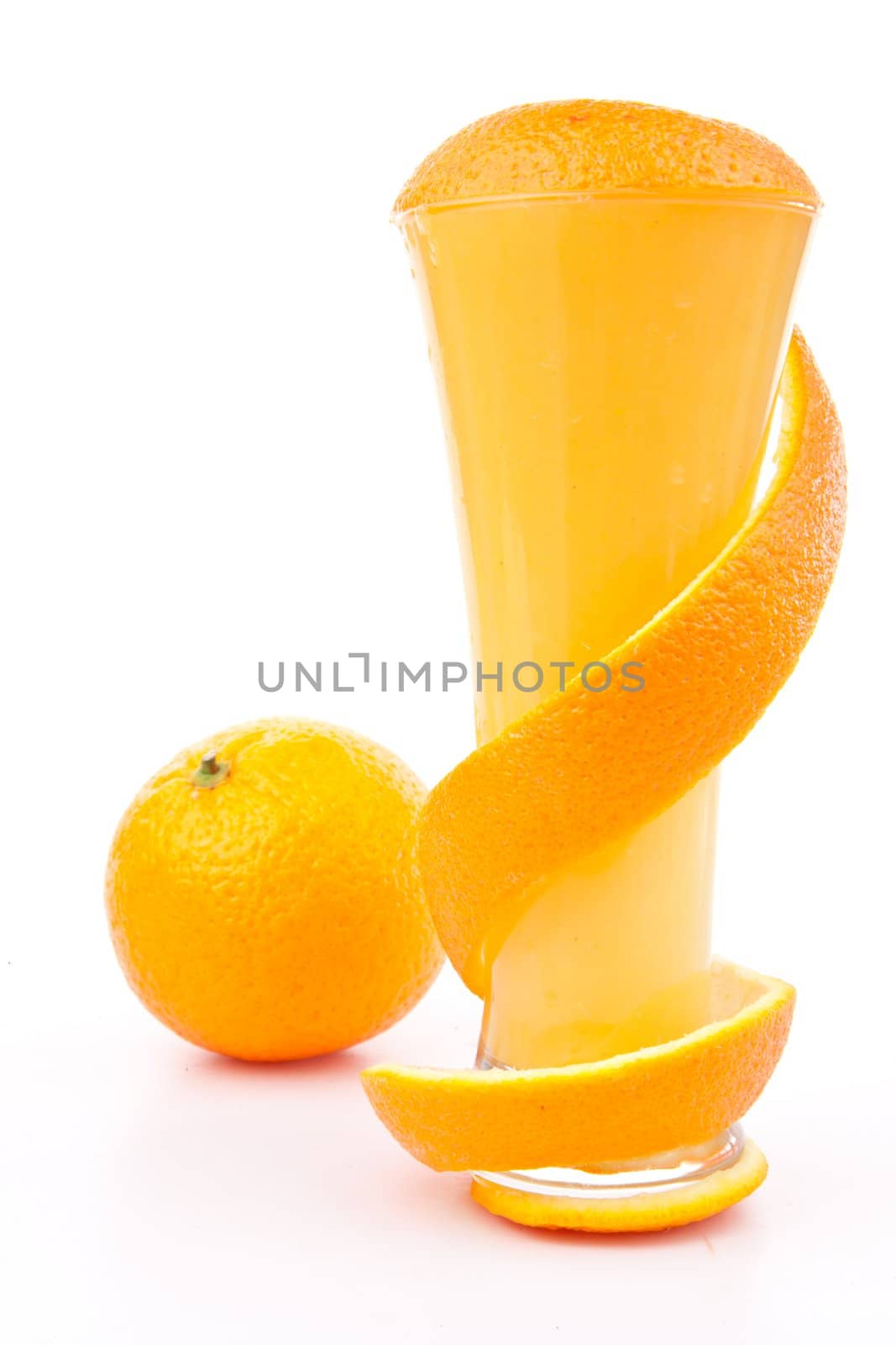 Orange peel wrapped around a glass against white background