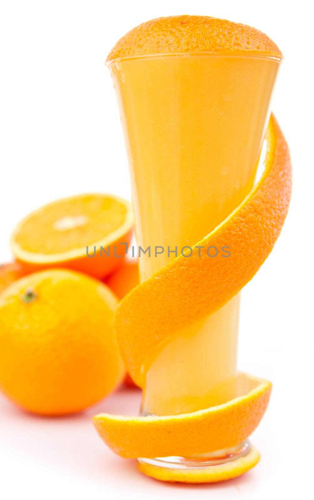 Orange peel wound around a glass against white background