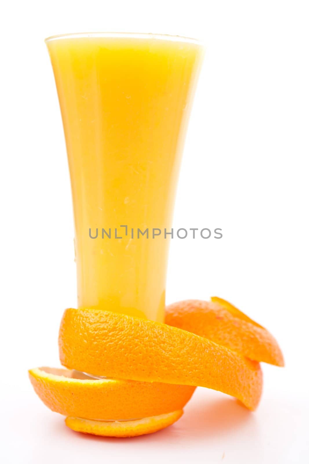 orange peel at the base of a glass against white background