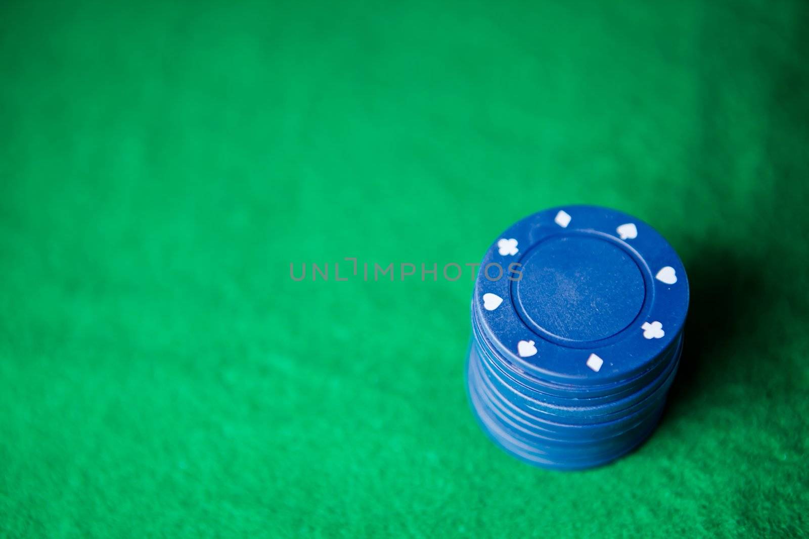 Blue poker chips on the green mat