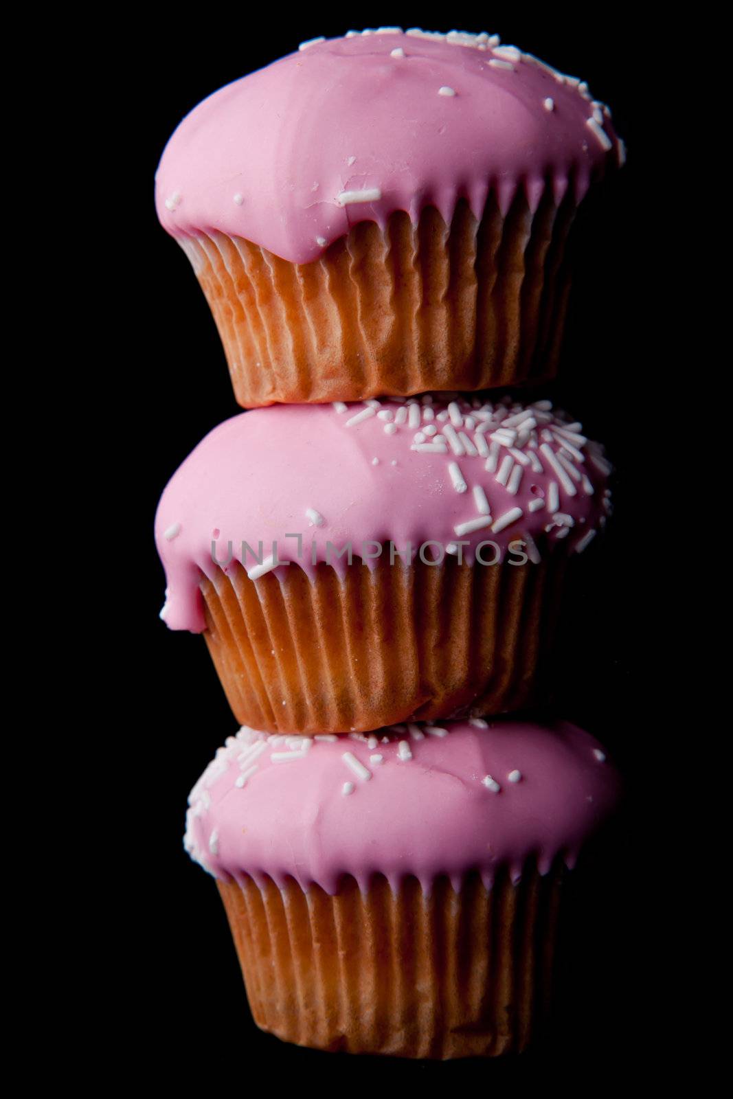 Pink cupcakes against a black background