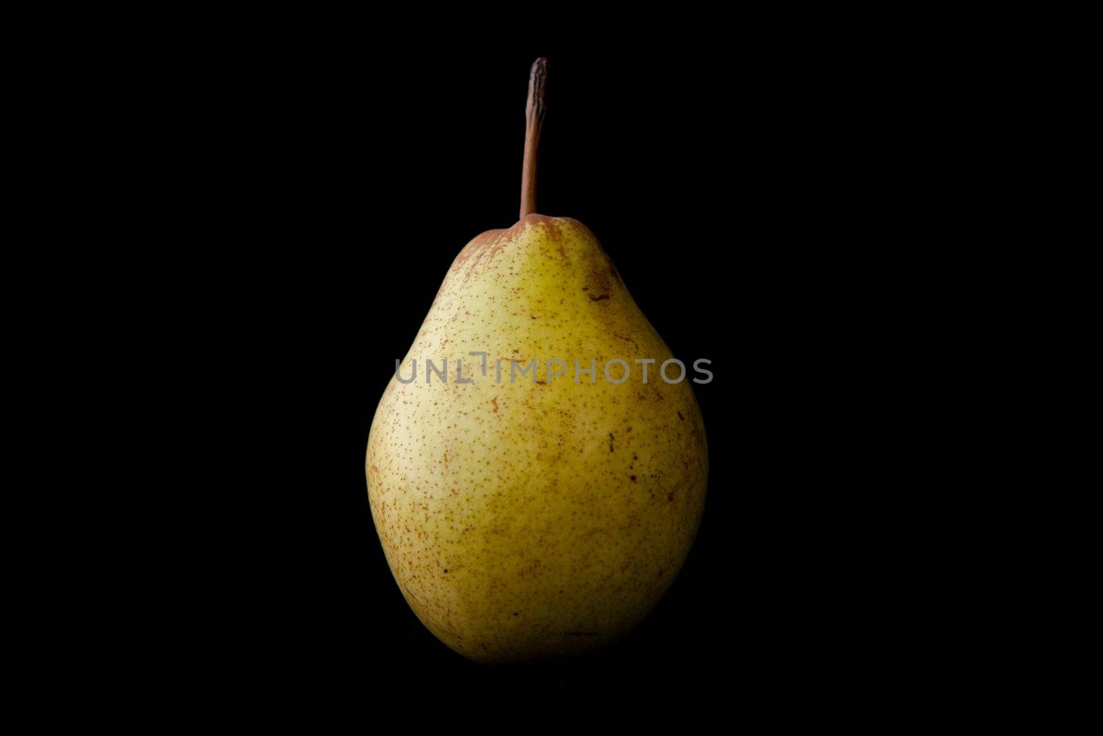 Green pear against a black baclground