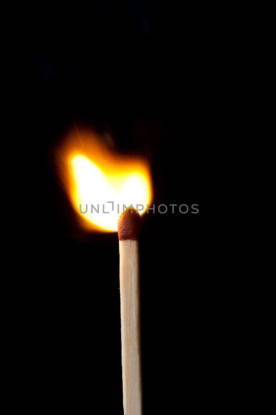 Close up of a match on fire against a black background