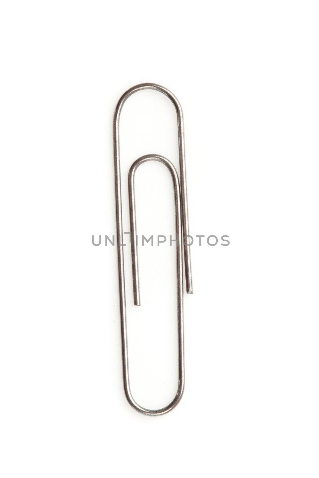 Close up of a grey paperclip on the floor against a white background
