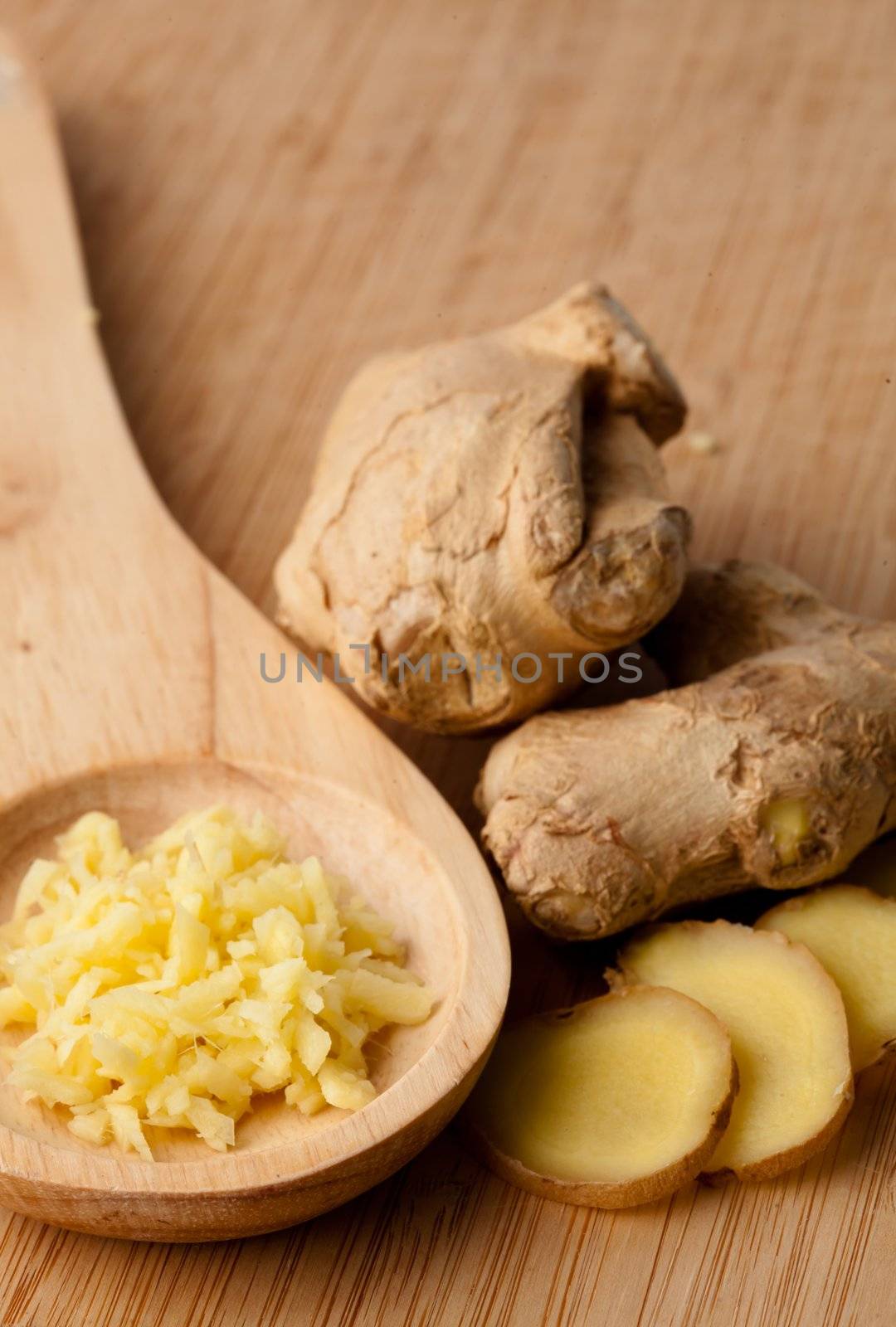 Close up of different forms of ginger against a wood worktop