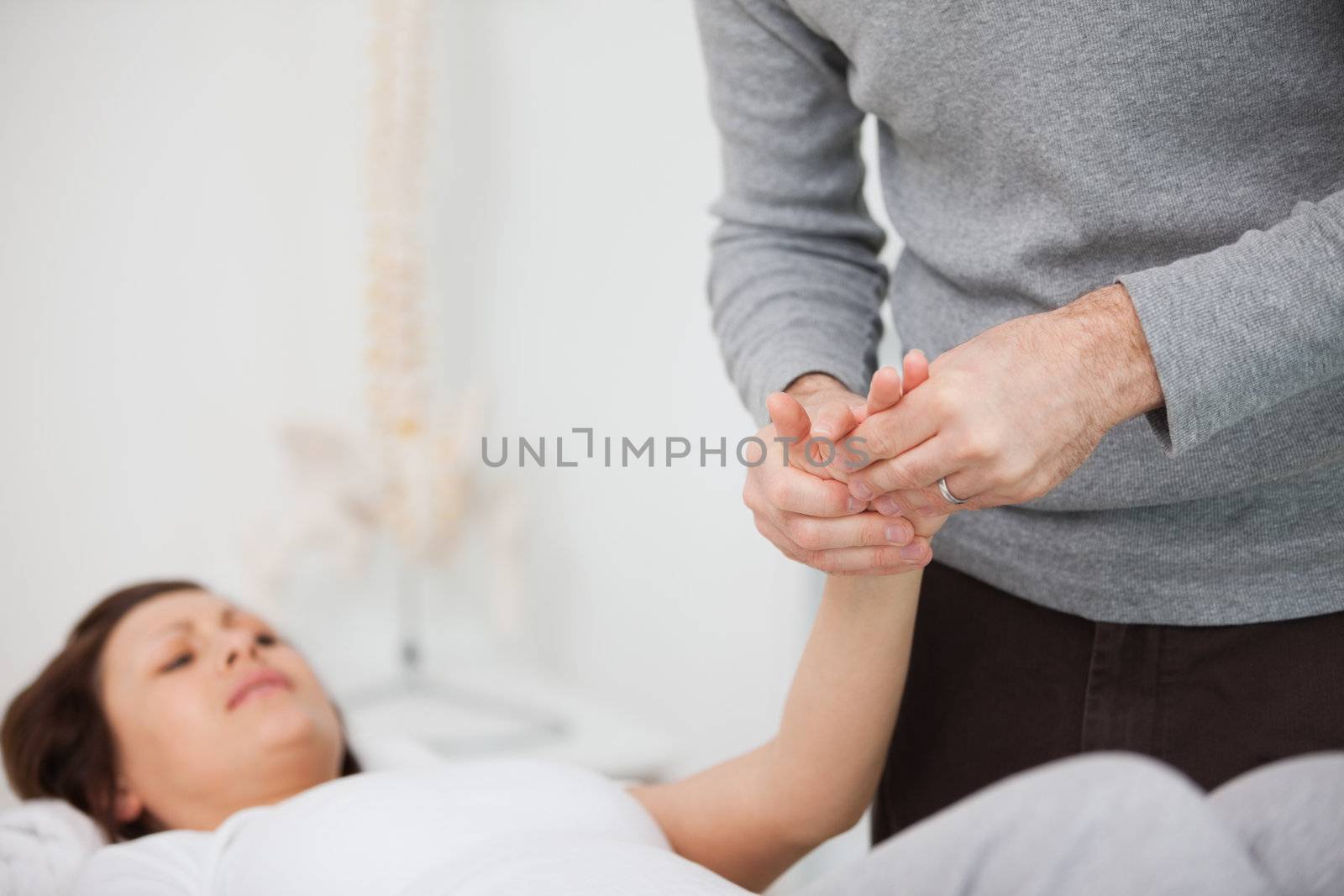 Physiotherapist massaging a painful hand indoors