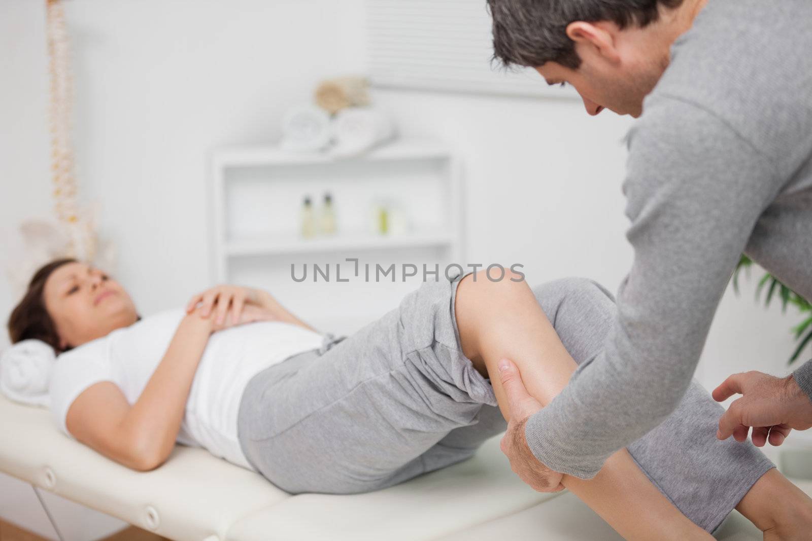 Physiotherapist massaging a calf in a room
