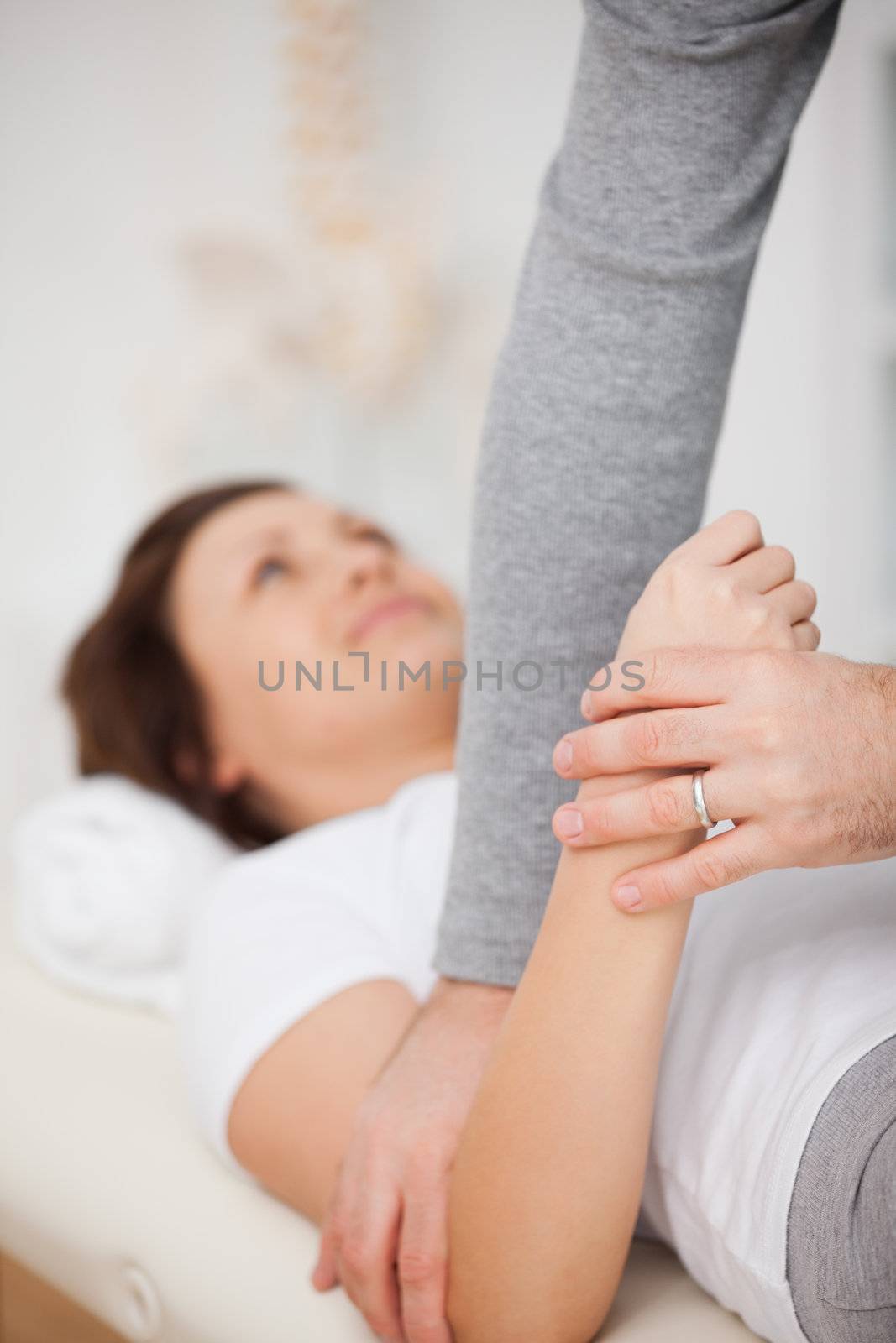 Physiotherapist manipulating the arm of a patient in a room