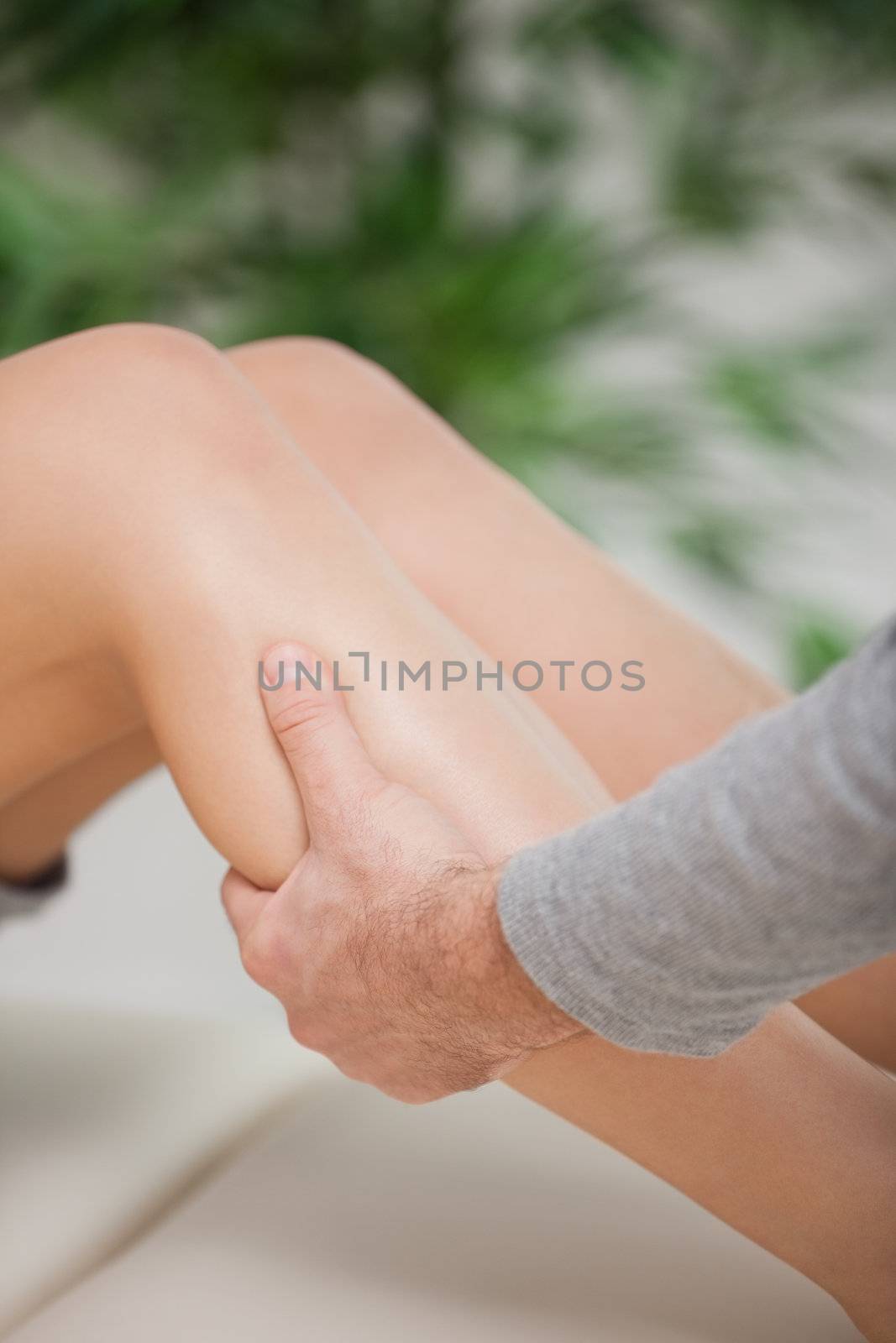 Osteopath holding the calf of a patient in a room