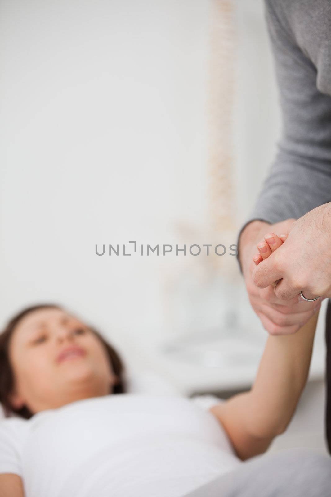 Physiotherapist holding a painful hand in a room