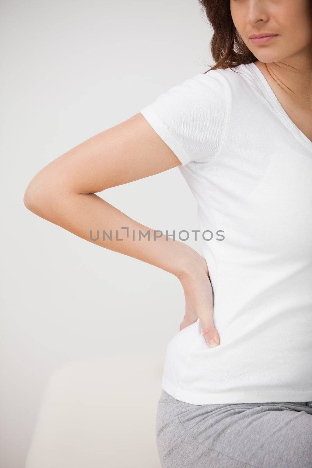 Woman massaging her painful hip while sitting by Wavebreakmedia