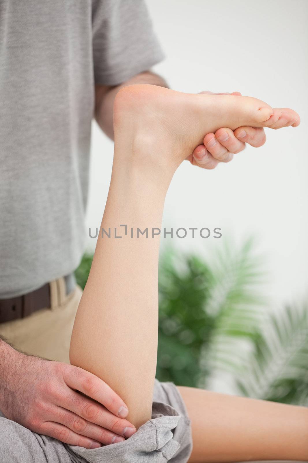 Woman lying forward while being stretched in a room