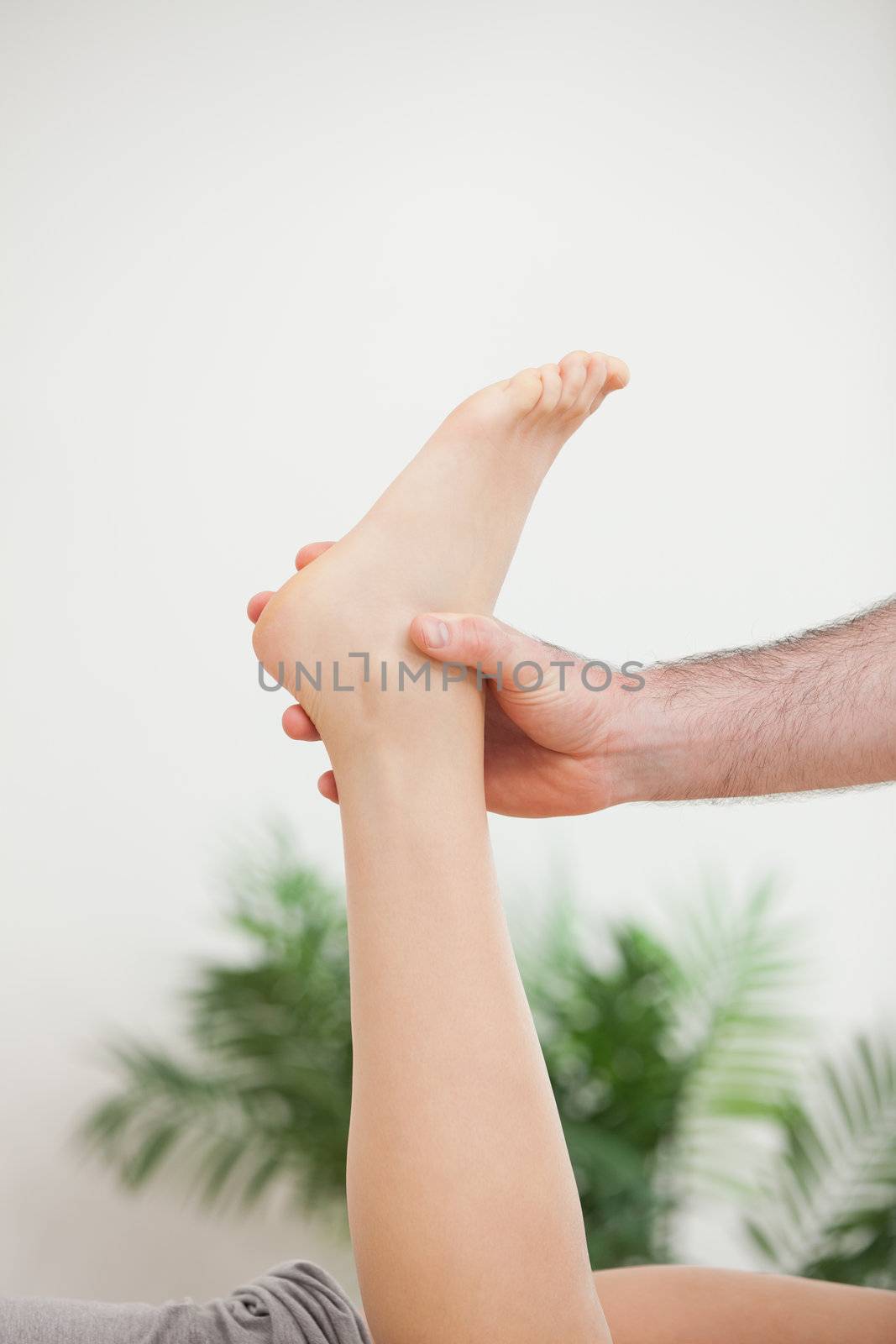 Doctor holding the foot of his patient in a room