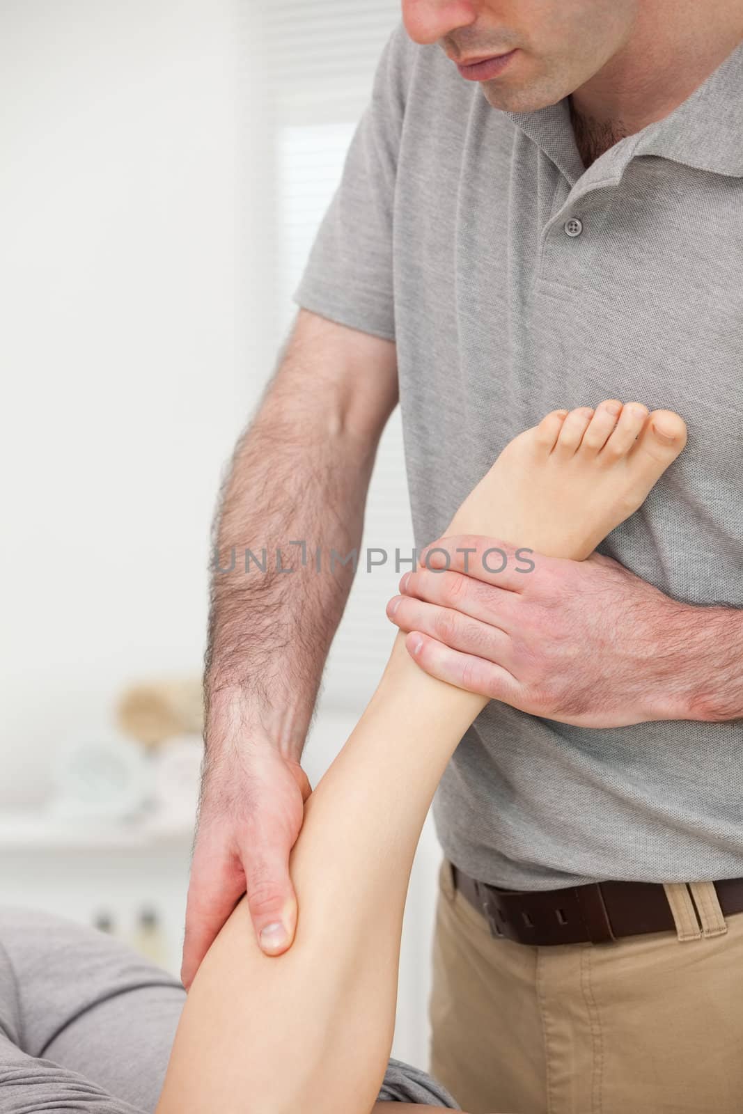 Doctor massaging the leg of a woman while she is lying by Wavebreakmedia