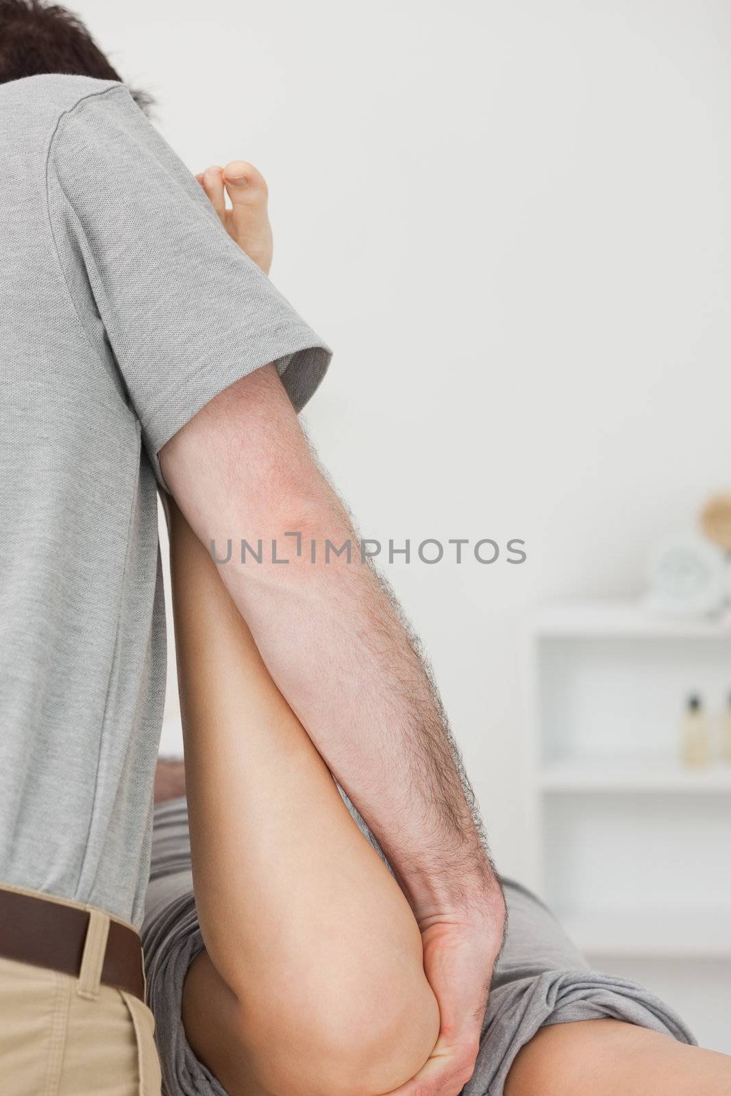 Physiotherapist manipulating the leg of a patient by Wavebreakmedia