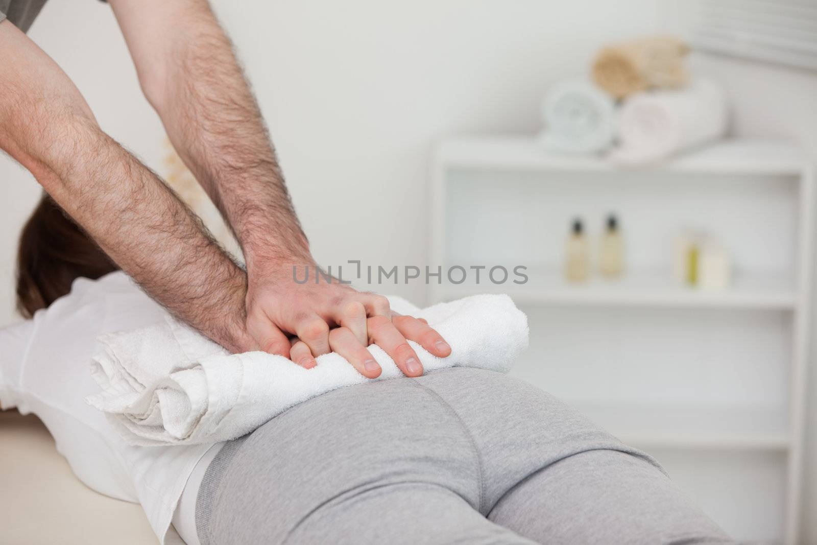 Masseur massaging a woman with a towel in a physio room