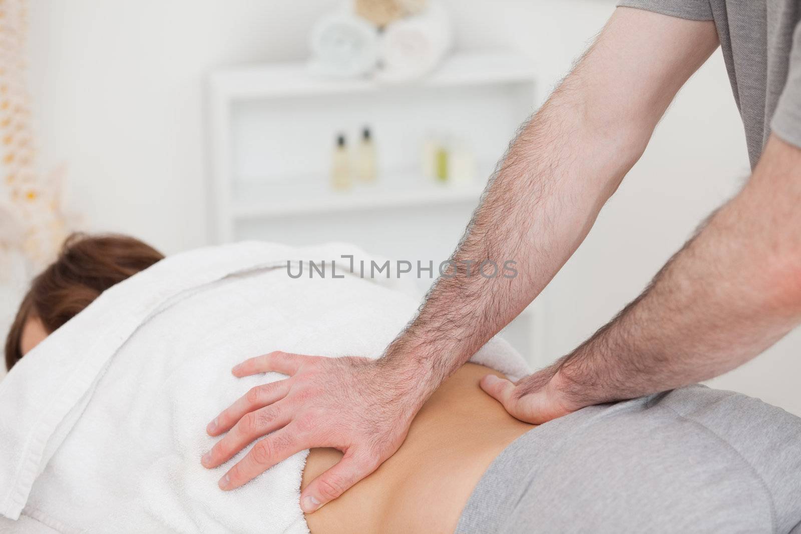 Masseur massaging the back of a woman in a room