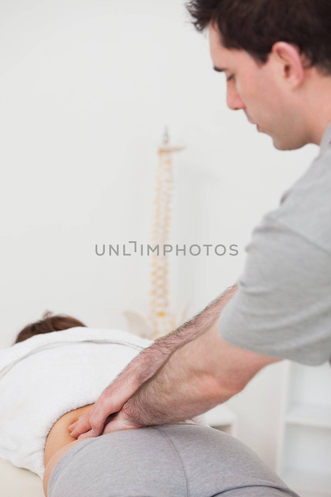 Physiotherapist massaging the lower part of the back of his pati by Wavebreakmedia