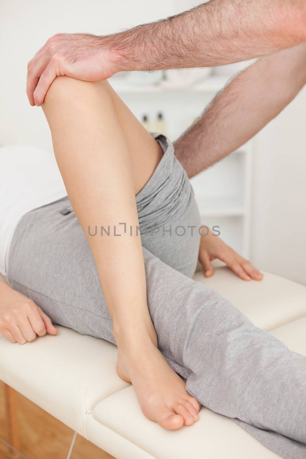 Physiotherapist crossing the leg of his patient in a physio room