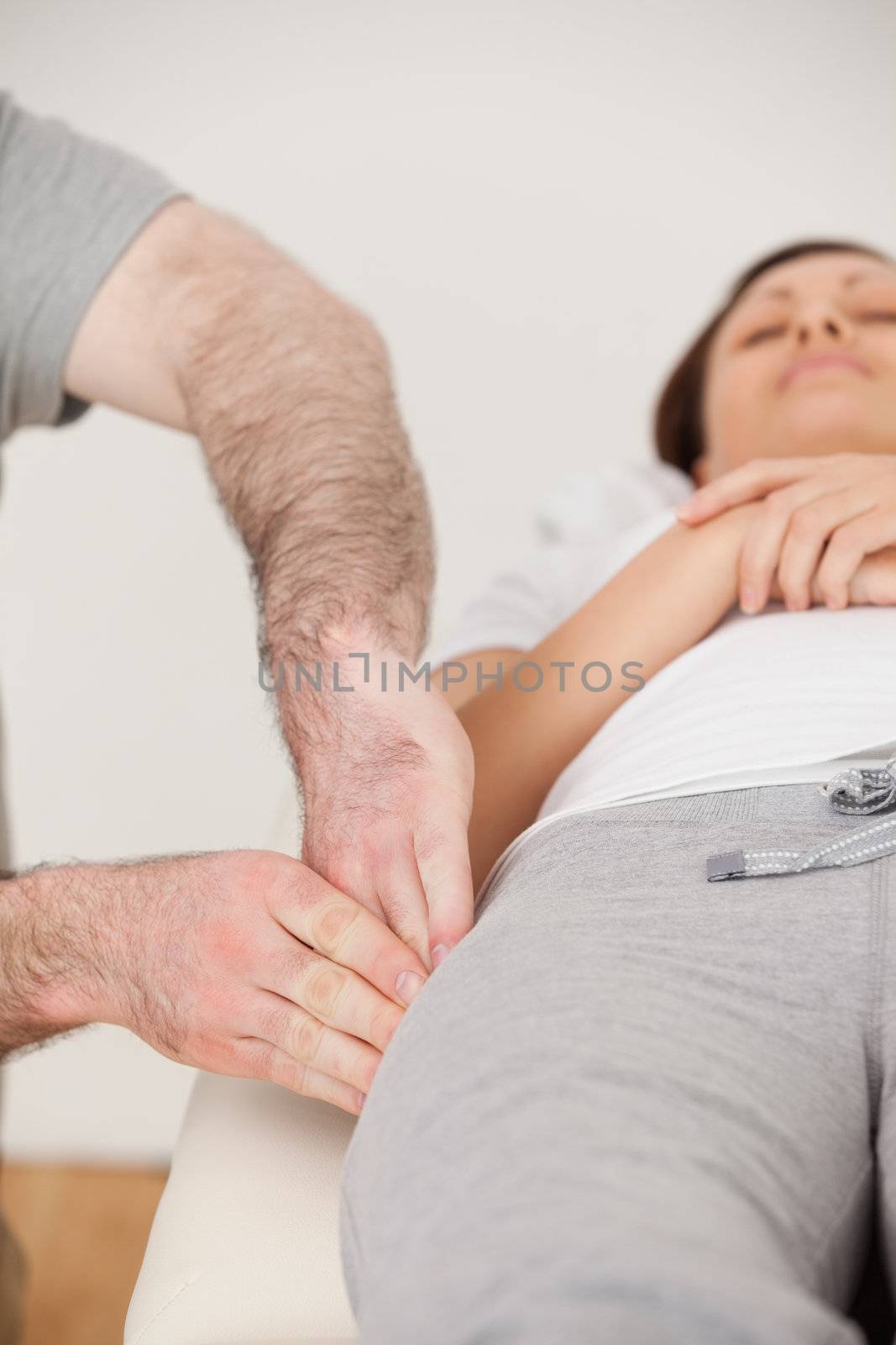 Physiotherapist massaging the thigh of his peaceful patient by Wavebreakmedia