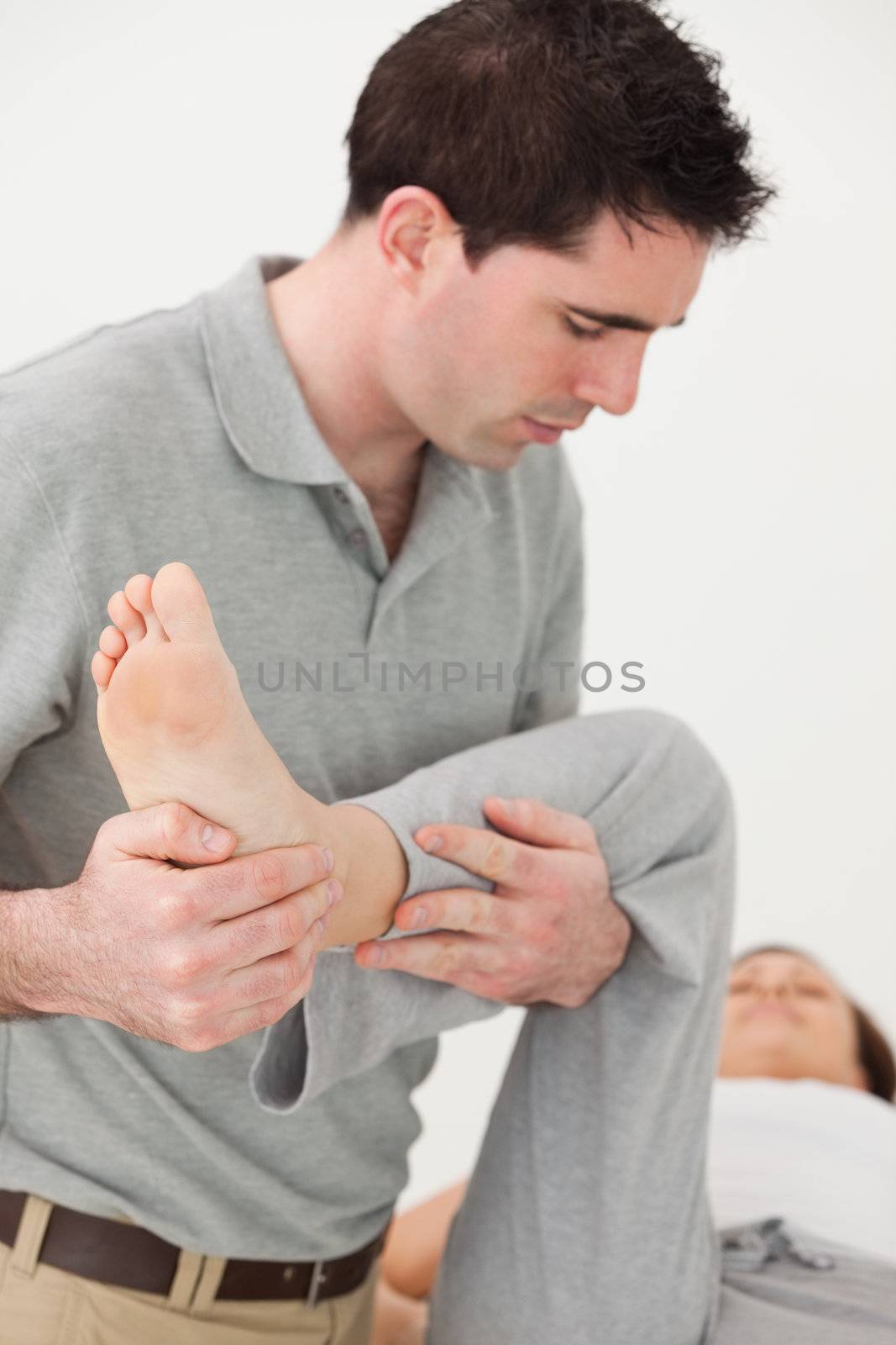 Woman lying on a table while being manipulated by Wavebreakmedia