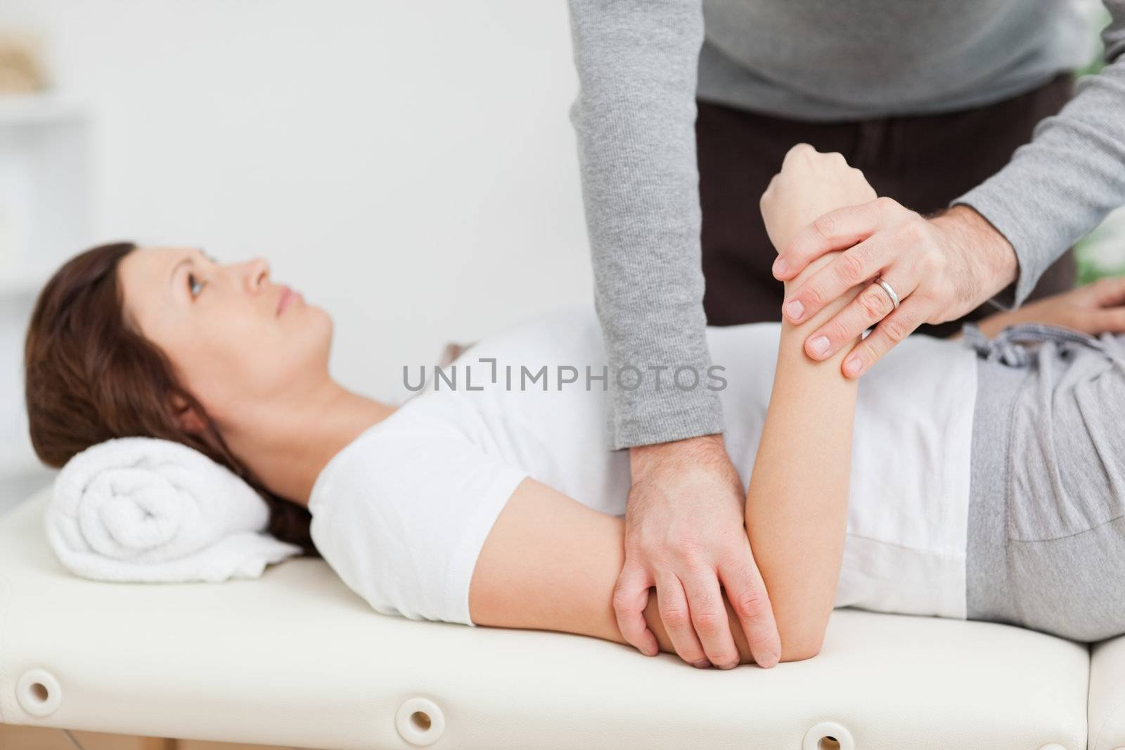 Physiotherapist manipulating the arm of a peaceful woman by Wavebreakmedia