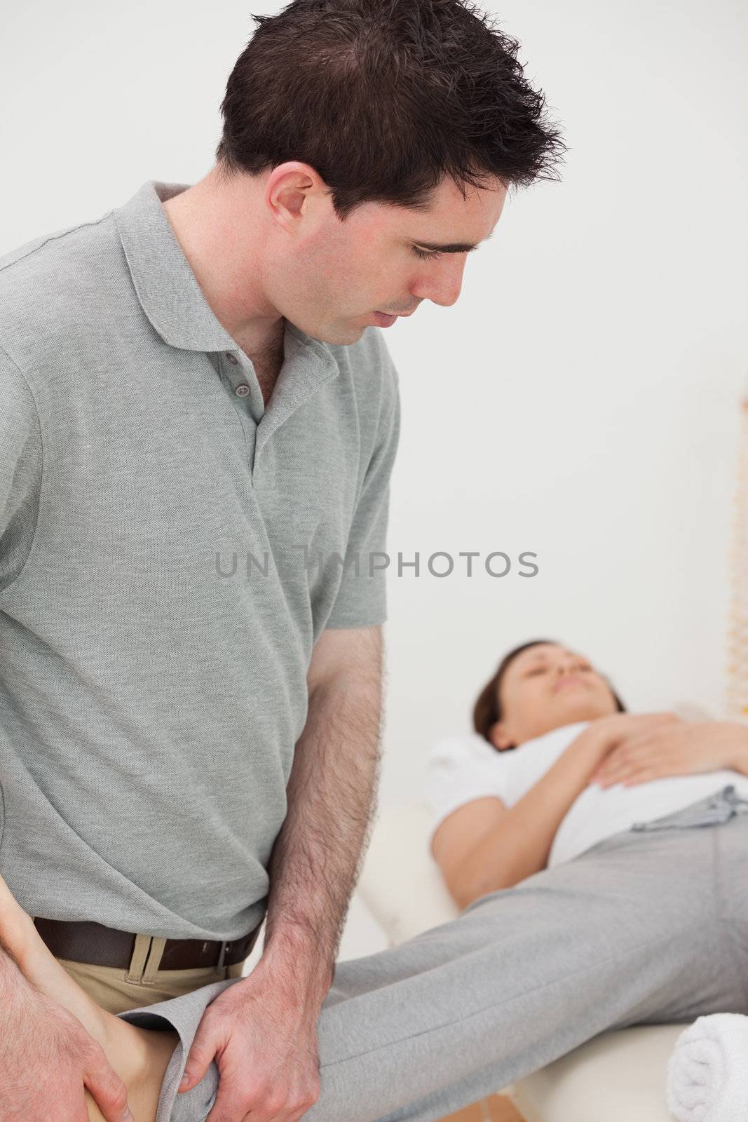 Physiotherapist stretching the leg of a woman in a room