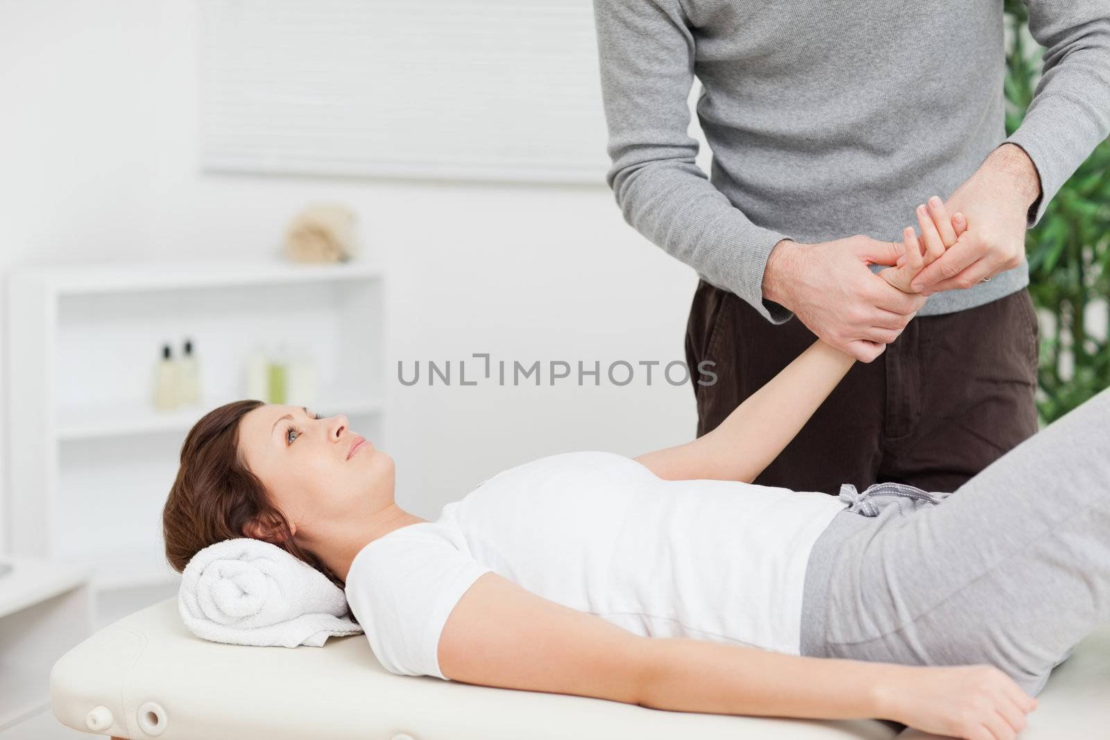 Physiotherapist massaging the hand of a woman in a physio room