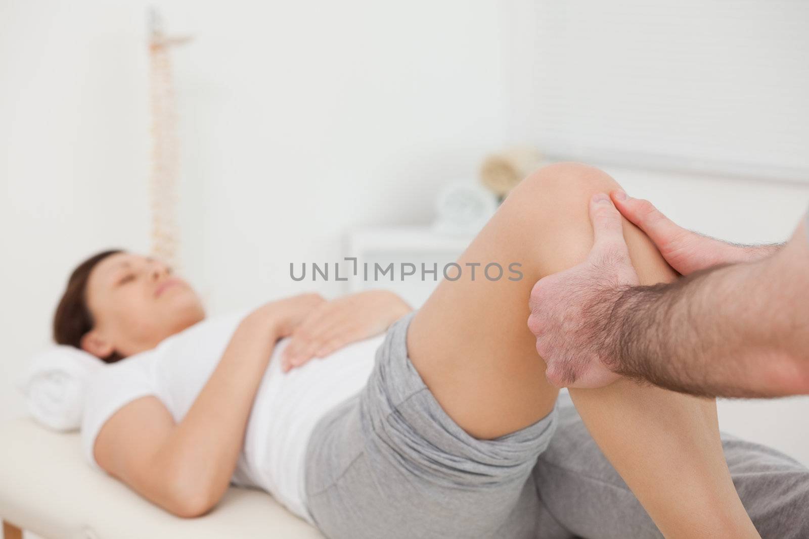 Woman lying while being massaged by her practitioner indoors