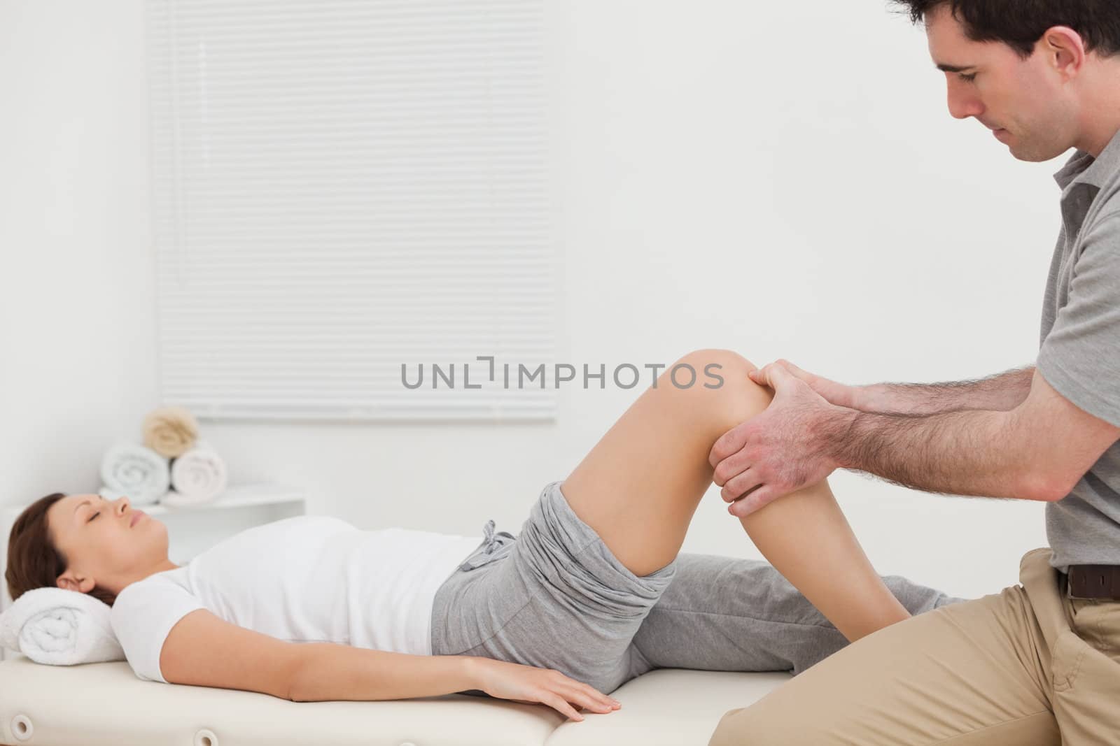 Man massaging the knee of a woman while sitting in a room