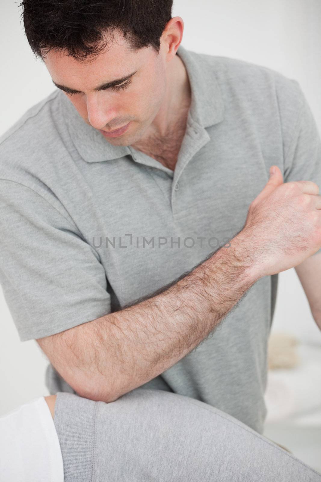 Physiotherapist using his elbow on the hip of a woman in a room