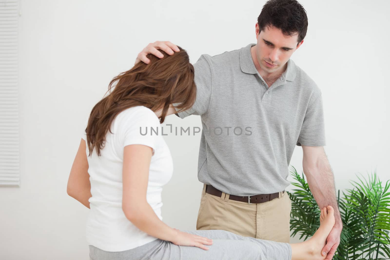 Serious doctor examining his patient in a room