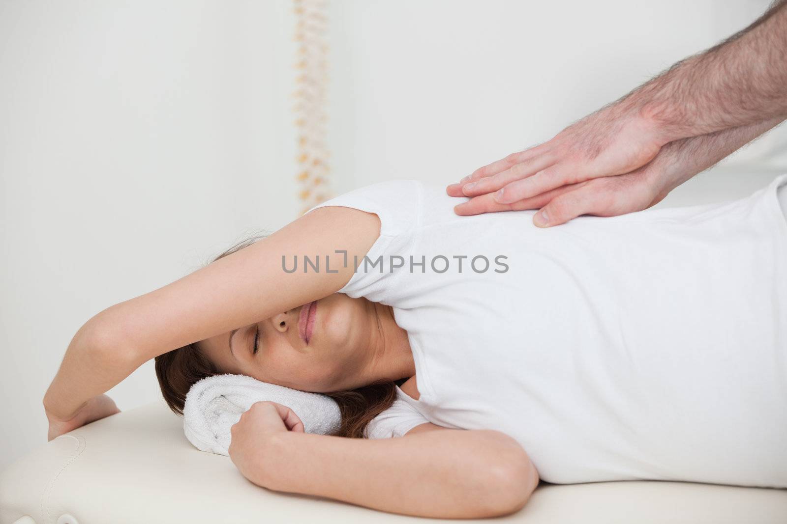 Woman lying on the side while being massaged in a room