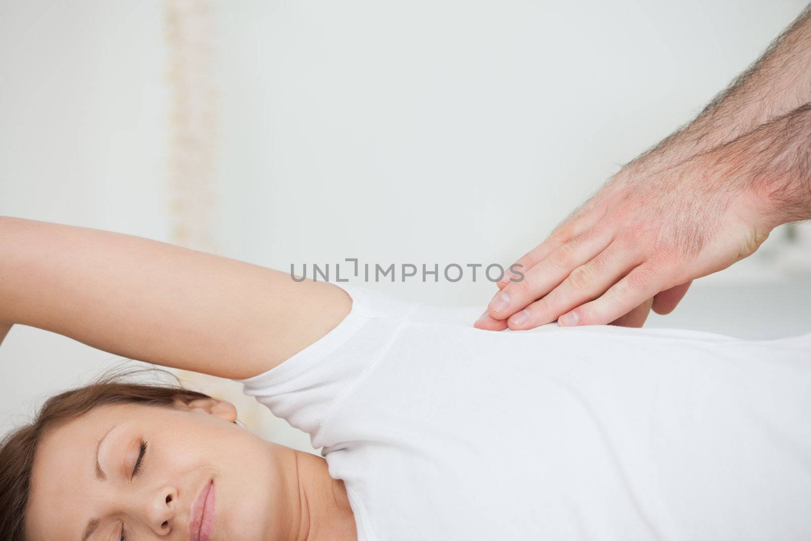 Peaceful patient being massaged by a doctor in a room