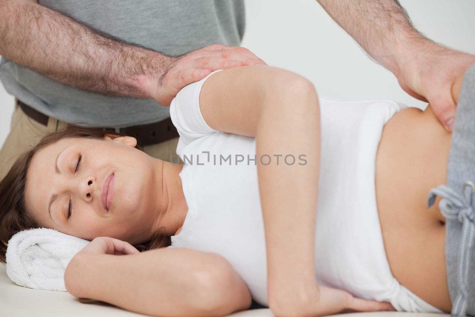 Brunette woman being massaged by her osteopath in a room
