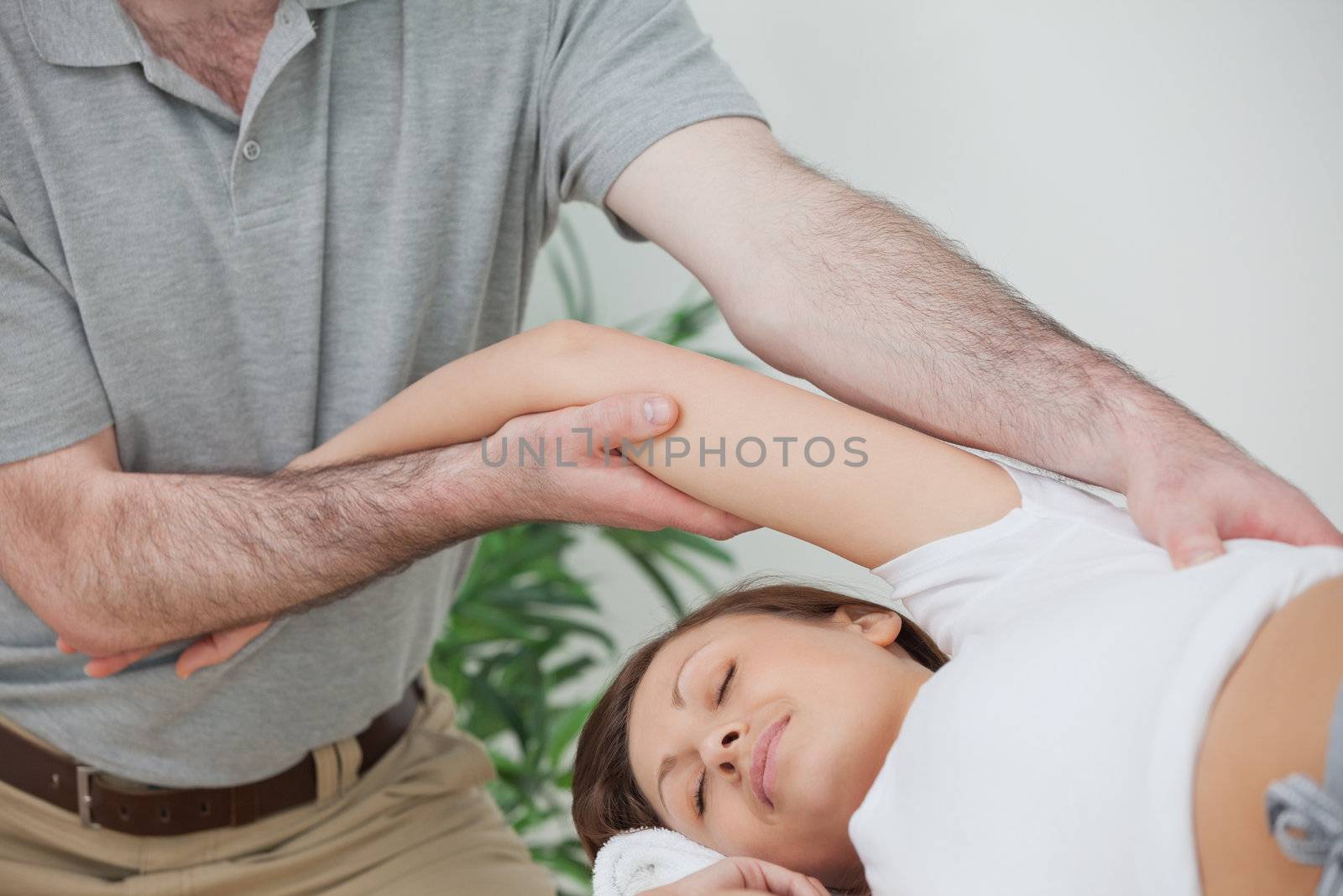 Woman being stretched while lying on a table by Wavebreakmedia