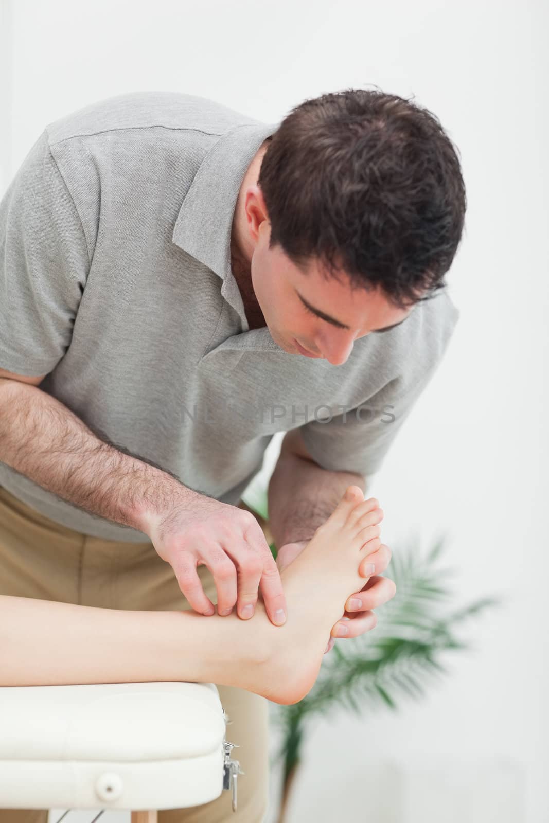 Podiatrist examining the foot of a patient in a room